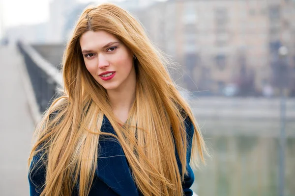 Porträt einer jungen schönen Frau im blauen Mantel — Stockfoto