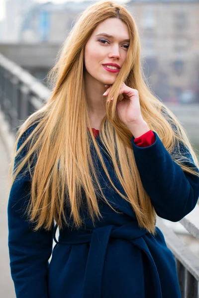 Retrato de una joven mujer hermosa con abrigo azul — Foto de Stock