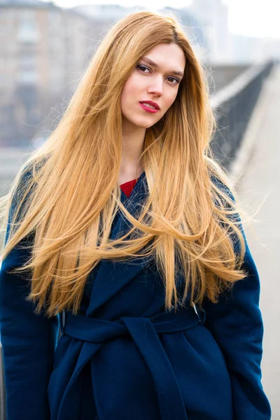 Porträt einer jungen schönen Frau im blauen Mantel — Stockfoto
