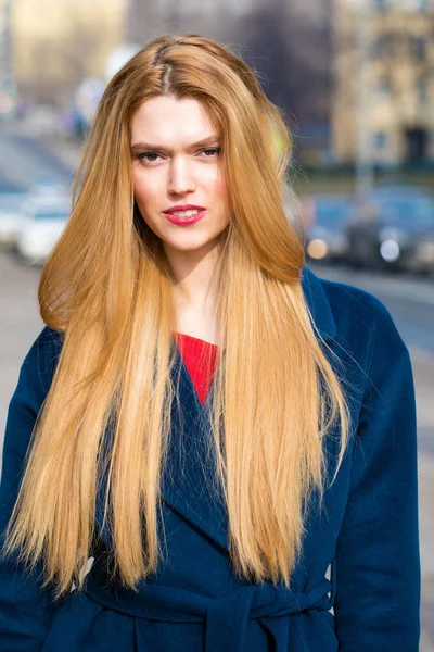 Mavi paltolu güzel bir genç kadın portresi 