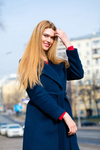 Portrait of a young beautiful woman in blue coat — Stock Photo, Image