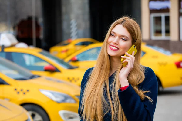 Ein junges Mädchen telefoniert mit einem Taxi. — Stockfoto