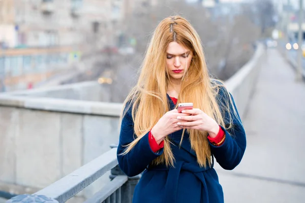 Portrait of a young beautiful woman in blue coat — Stock Photo, Image