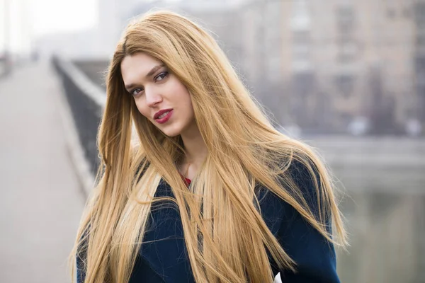 Retrato de una joven mujer hermosa con abrigo azul — Foto de Stock