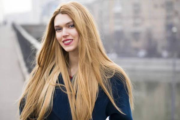 Portrait of a young beautiful woman in blue coat — Stock Photo, Image