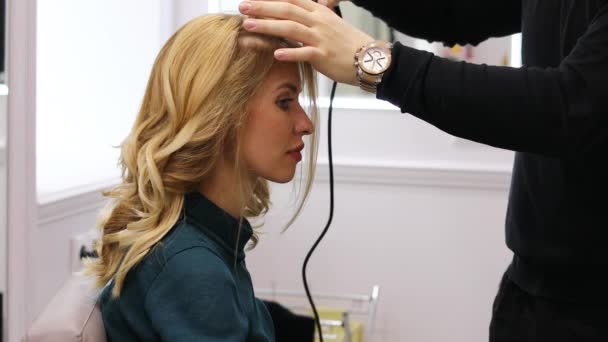 Styling μαλλιών στο σαλόνι ομορφιάς. Νέοι όμορφη ξανθιά μοντέλο στο κομμωτήριο — Αρχείο Βίντεο
