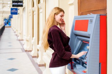 Arka planda alışveriş merkezi Atm üzerinde sarışın kadın