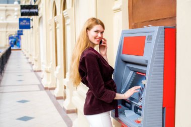 Arka planda alışveriş merkezi Atm üzerinde sarışın kadın