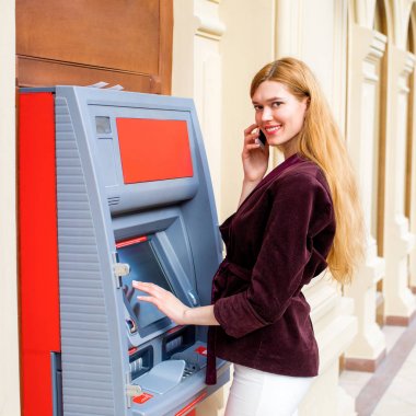 Arka planda alışveriş merkezi Atm üzerinde sarışın kadın