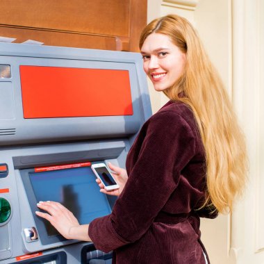 Arka planda alışveriş merkezi Atm üzerinde sarışın kadın