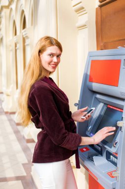 Arka planda alışveriş merkezi Atm üzerinde sarışın kadın