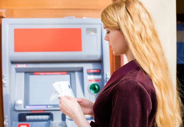 Encaisser de l'argent à un distributeur automatique — Photo