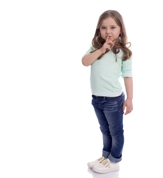 Güzel küçük bir kız işaret parmağı dudaklarını sile işareti olarak koymuştur — Stok fotoğraf