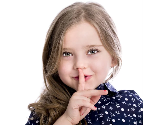 Piękna dziewczynka ma położyć palec wskazujący usta jako znak sile — Zdjęcie stockowe