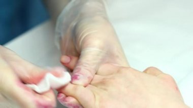 Sünger, parmaklar üzerinde cuticles Temizleme. Bir tırnak salonu manikür alma kadında