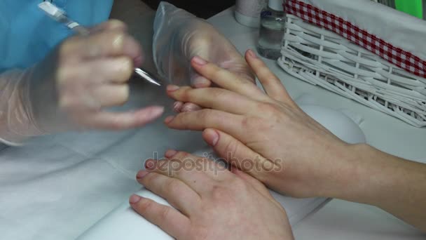 Schoonmaken van de nagelriemen op vrouwelijke vingers. Model in een nagel salon ontvangen een manicure — Stockvideo