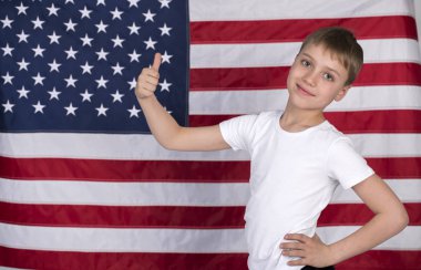 Arka planda Amerikan bayrağı ile beyaz küçük çocuk