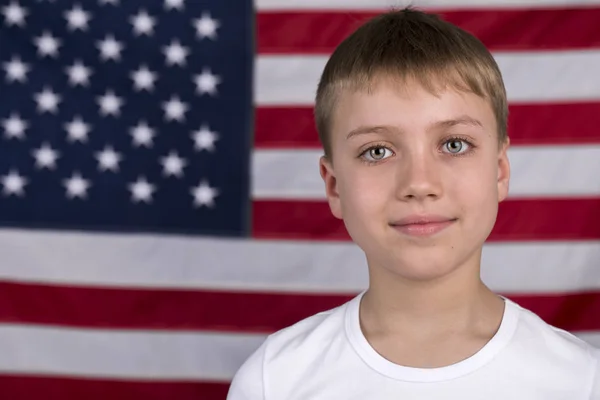 Ragazzino caucasico con bandiera americana sullo sfondo — Foto Stock