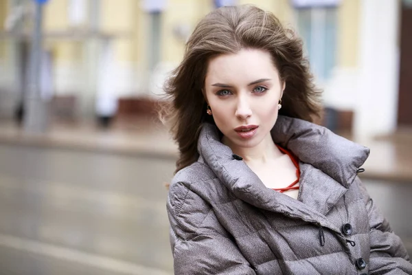 Retrato de una joven morena con estilo en una chaqueta gris —  Fotos de Stock