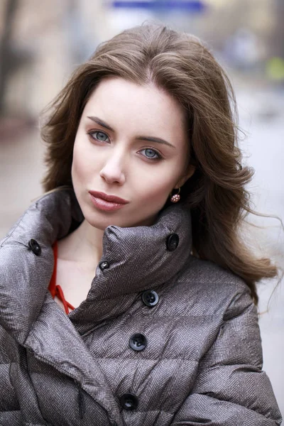 Portrait of a Young stylish brunette girl in a gray down jacket — Stock Photo, Image