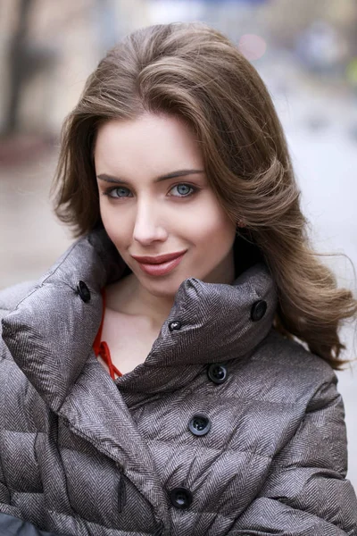Retrato de una joven morena con estilo en una chaqueta gris —  Fotos de Stock