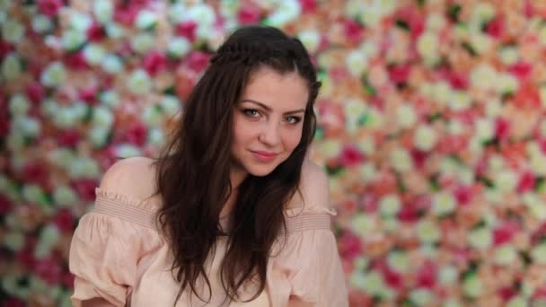 Retrato de jovem modelo sexy em vestido rosa, fundo da parede floral brilhante — Vídeo de Stock