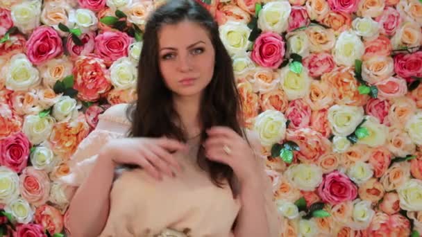 Retrato de joven modelo morena hermosa bailando, de cerca sobre un fondo de brillante pared floral — Vídeo de stock