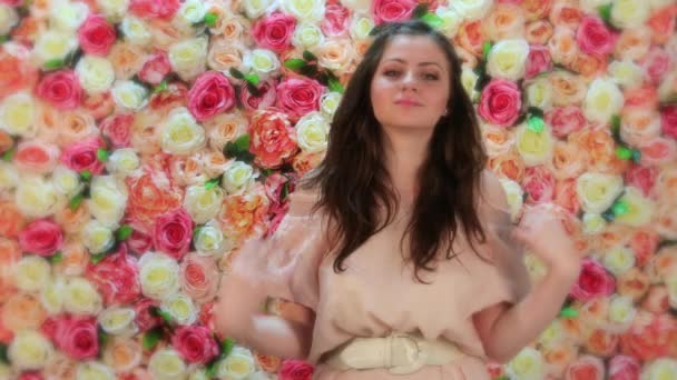 Romantic. Portrait of young beautiful brunette woman dancing, close up on a background of bright floral wall — Stock Video