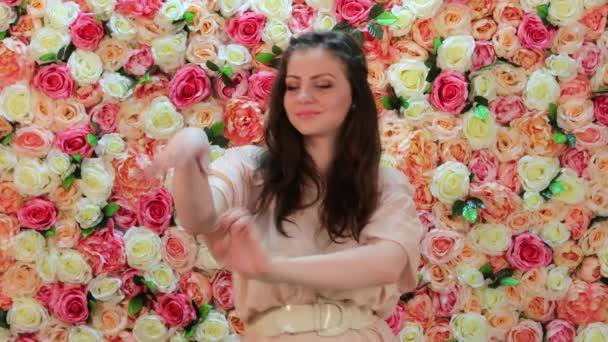 Porträtt av ung vacker brunett dansare flicka, närbild på en bakgrund av ljusa blommiga väggen — Stockvideo