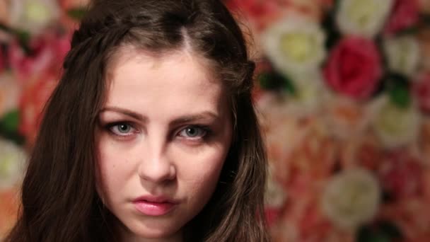 Retrato de joven modelo hermoso, primer plano sobre un fondo de pared floral brillante — Vídeo de stock