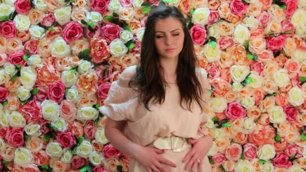 Portrait of young beautiful girl, closeup on a background of bright floral wall — Stock Video