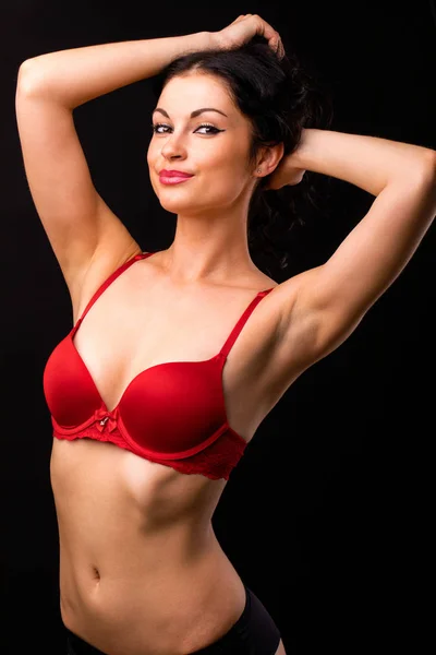 Portret van sexy brunette vrouw in rode en zwarte ondergoed op een — Stockfoto
