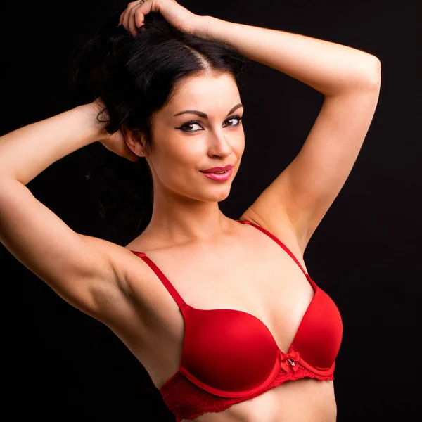 Porträt einer sexy brünetten Frau in roter und schwarzer Unterwäsche auf einem — Stockfoto