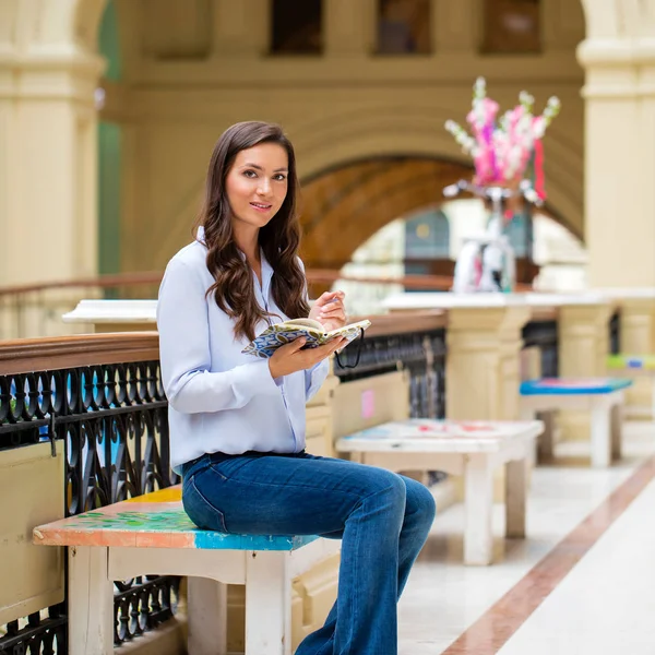 Jonge brunette vrouw met een notebook — Stockfoto