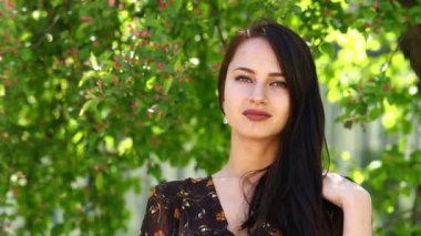 Mutlu esmer. Açık havada bahar park karşı poz bir yazlık elbise genç güzel kadın