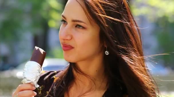 Ескімосів. Сексуальна молода брюнетка жінка, їдять морозиво, спекотне літо на відкритому повітрі — стокове відео
