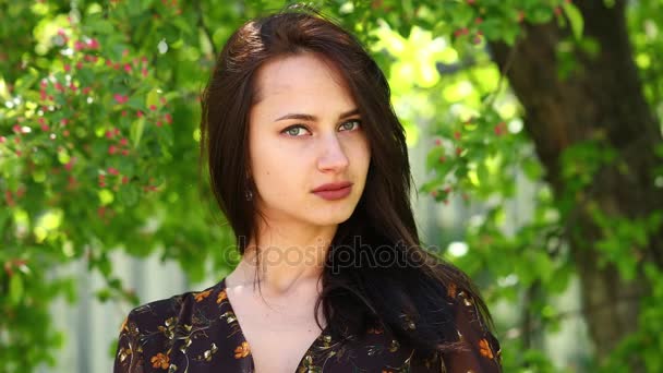 Joyeux Brunette. Jeune belle femme dans une robe d'été posant contre le parc de printemps à l'extérieur — Video