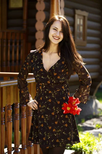 Happy brunette woman standing and posing in brown summer dress — Stock Photo, Image