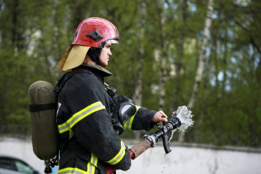 İtfaiyeci itfaiye su püskürtme takım elbise içinde surround ateş 