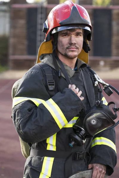 Retrato de un joven bombero en el fondo de un camión de bomberos —  Fotos de Stock