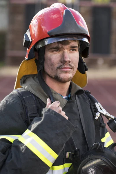 Portret młodego strażak na tle strażacki — Zdjęcie stockowe
