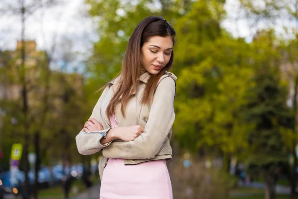 Hermosa joven morena mujer en vestido rosa y chaqueta gris — Foto de Stock