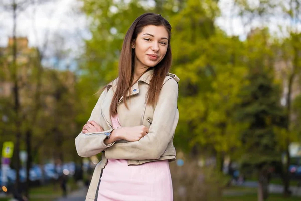 Güzel genç esmer kadın pembe elbisesi ve gri ceket — Stok fotoğraf
