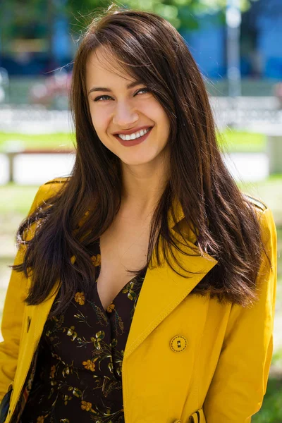 Portrét mladé krásné ženy ve žlutém plášti — Stock fotografie