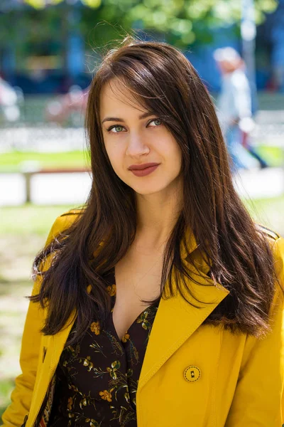 Ritratto di una giovane bella donna in cappotto giallo — Foto Stock