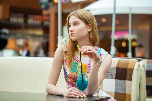 Jonge vrouw drinken cocktail in een café — Stockfoto