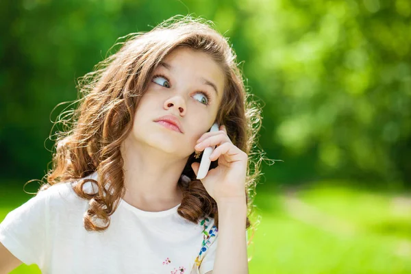 Portræt af en smuk ung pige, der ringer pr. telefon - Stock-foto