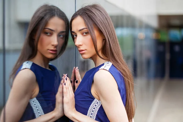 Stylish lady in blue dress posing near mirrored wall — Stock Photo, Image