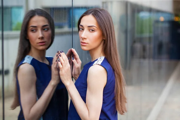 Senhora elegante em vestido azul posando perto de parede espelhada — Fotografia de Stock