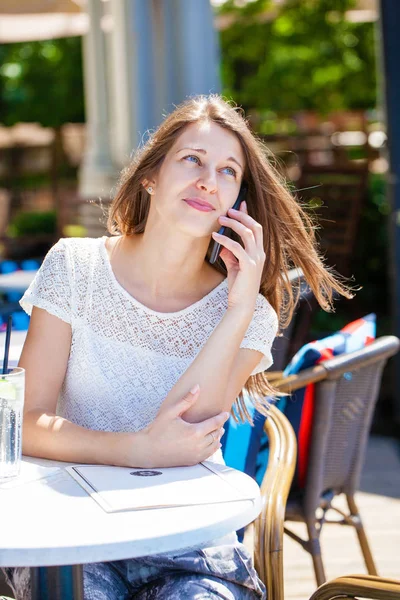 Güzel koyu saçlı genç kadın cep telefonunuza konuşan portresi